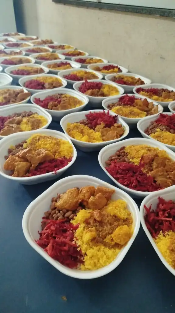 Dezenas de marmitas preparadas na cozinha solidária com cuscuz, feijão, carne e beterraba