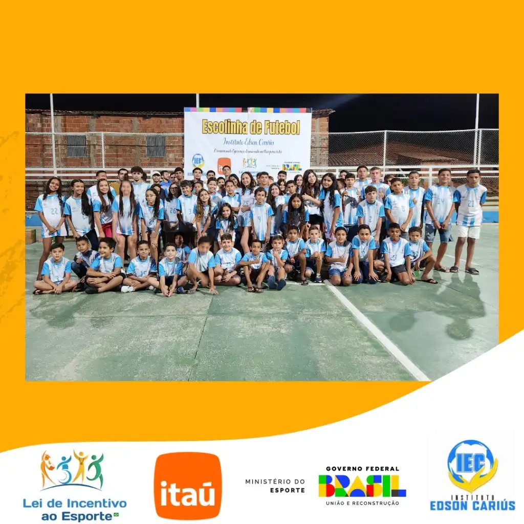 Grupo de crianças e adolescentes com uniformes da escolinha em formação no campo esportivo
