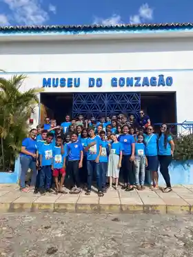 Grupo de crianças e adolescentes do instituto em visita ao Museu do Gonzagão, com camisetas azuis do IEC