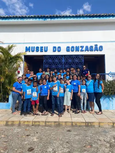 Grupo de crianças e adolescentes do instituto em visita ao Museu do Gonzagão, com camisetas azuis do IEC