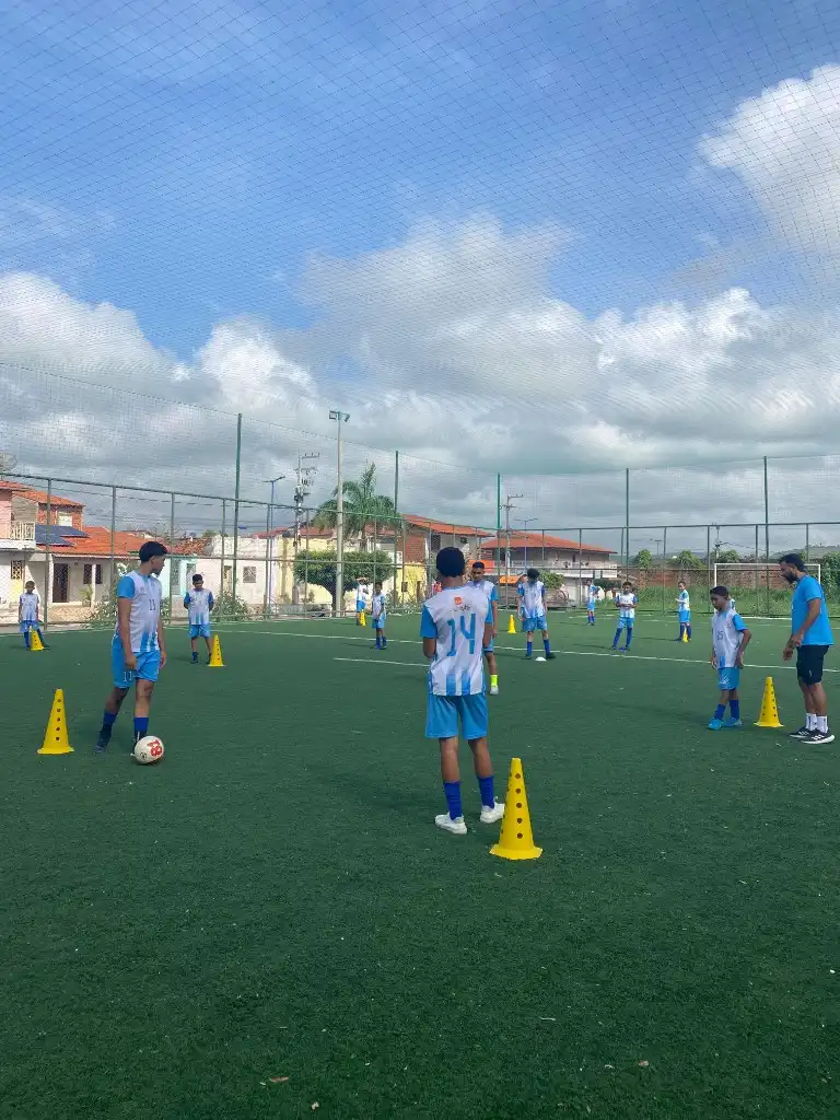 Crianças e adolescentes em treino de futebol no campo sintético do Instituto Edson Cariús